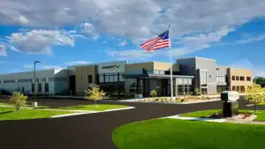 Modern Marco Technologies office building with American flag and landscaped surroundings, representing innovation and excellence in technology solutions.